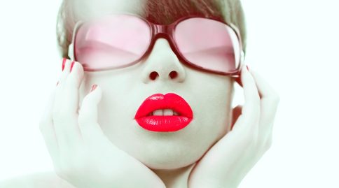 Glamour photo of red lipstick and red sunglasses on young woman