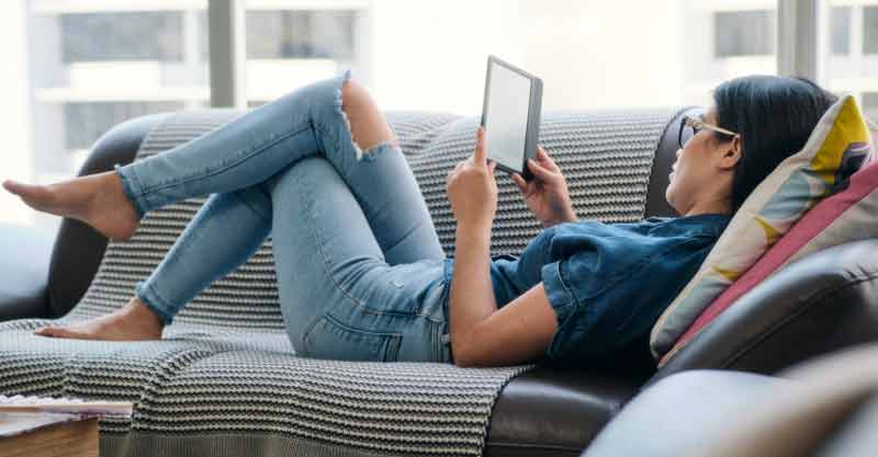 woman reading ebook on couch